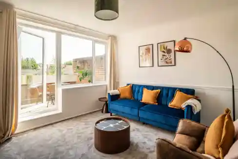 Bright living room with blue sofa and large window in Canary Wharf.