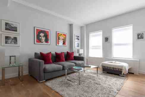 Bright living room with artwork, sofa, and natural light.