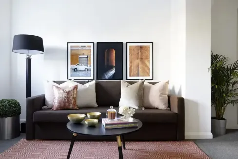Modern living room with sofa, artwork, and decor in Upton Watford Suite.