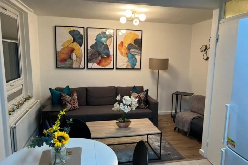 Cozy living room with sofa, artwork, and decorative pillows in Tottenham Hale.