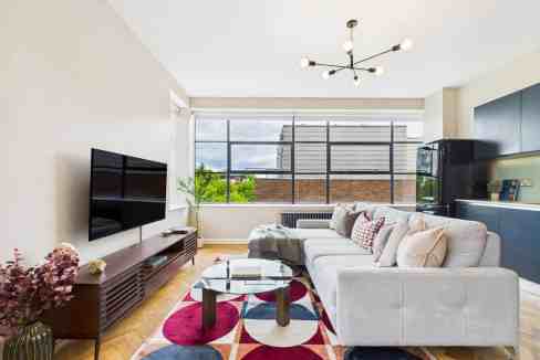 Bright modern living room with large window and stylish furniture.