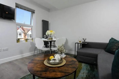 Modern living room with sofa, dining area, and window view.
