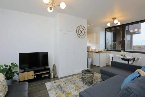 Modern living room in Upton Watford serviced apartment with sofa and TV.