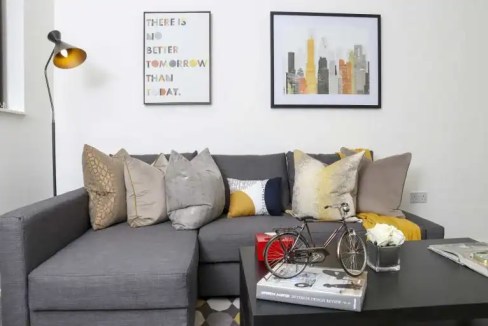 Contemporary living room with sofa, artwork, and accessories.