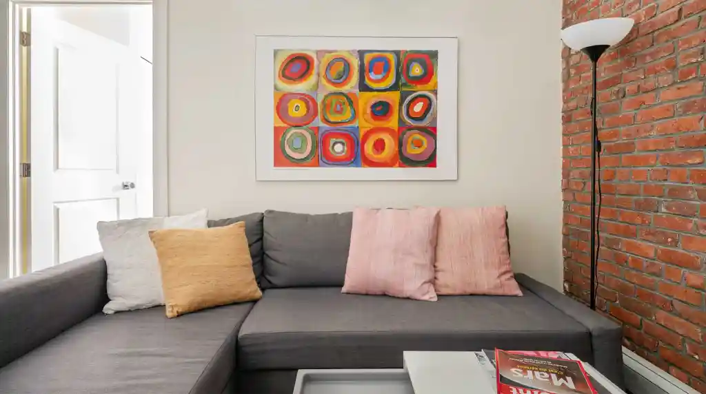 Contemporary living room with colorful abstract wall art and cozy sofa.