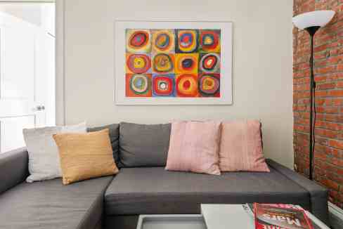 Contemporary living room with colorful abstract wall art and cozy sofa.