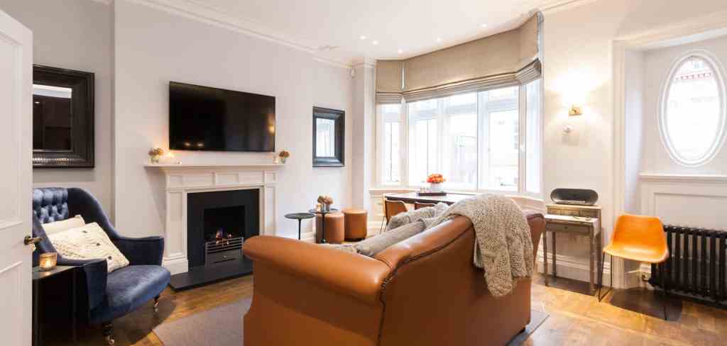 Spacious living room with fireplace, large windows, and modern furniture.