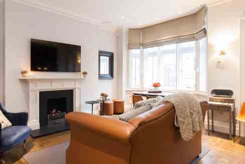 Spacious living room with fireplace, large windows, and modern furniture.