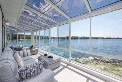 Bright sunroom with panoramic bay views and comfortable seating.