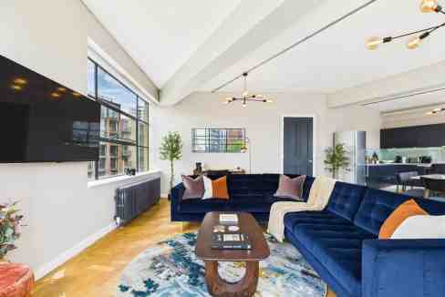 Bright living room with large windows and city skyline view.