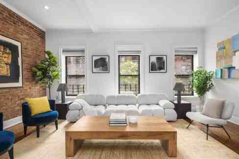 Stylish living room with white sofa, colorful chairs, and artwork in Flatiron Designer Luxe.