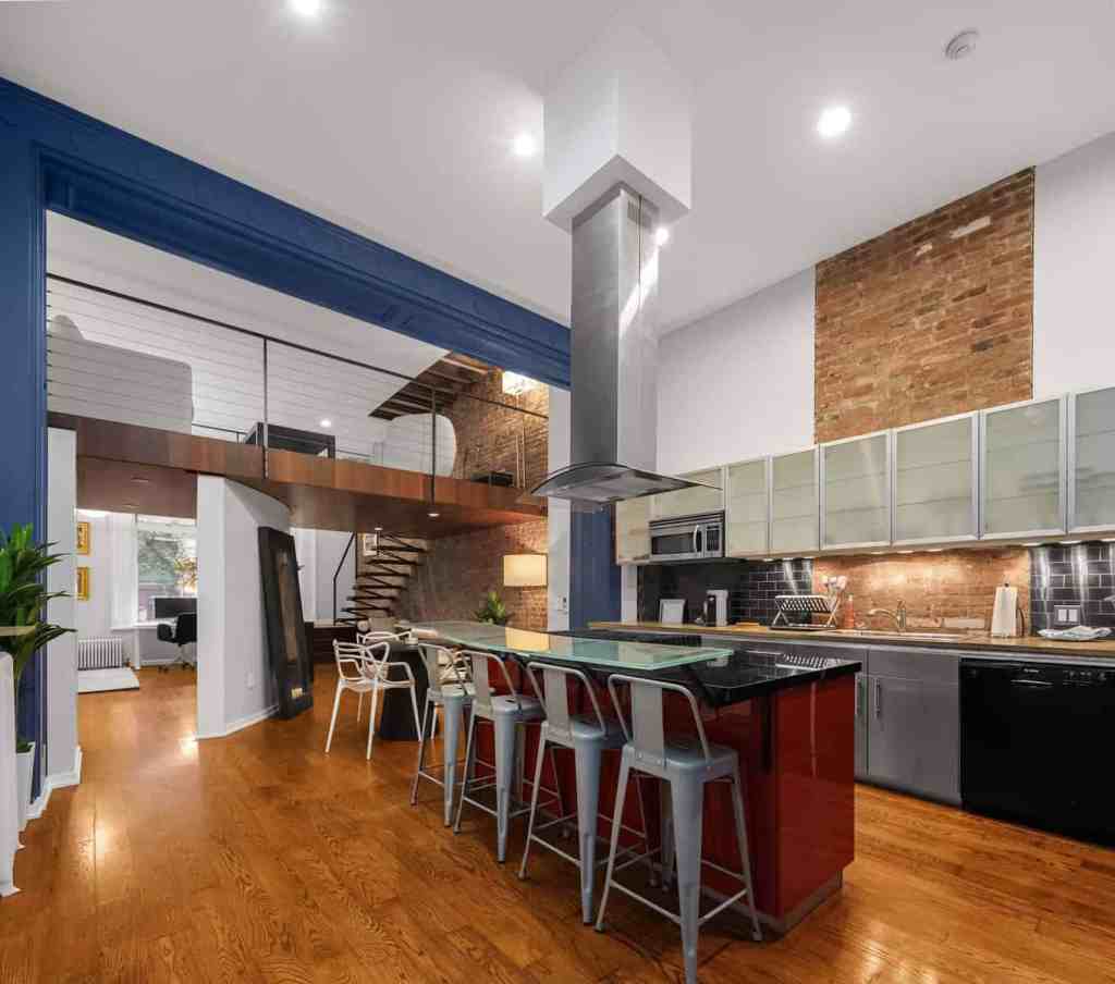 Contemporary kitchen with exposed brick walls and sleek appliances.