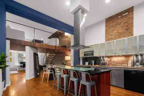 Contemporary kitchen with exposed brick walls and sleek appliances.