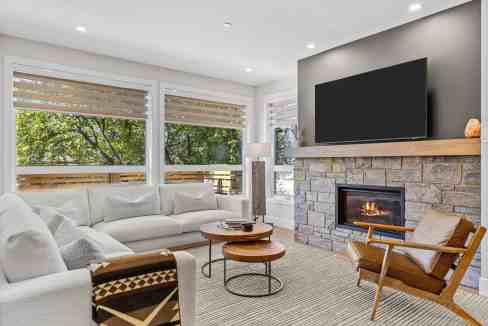 Bright living room with large windows, fireplace, and contemporary furniture.