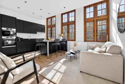 Bright living room with large wooden windows and contemporary furniture.