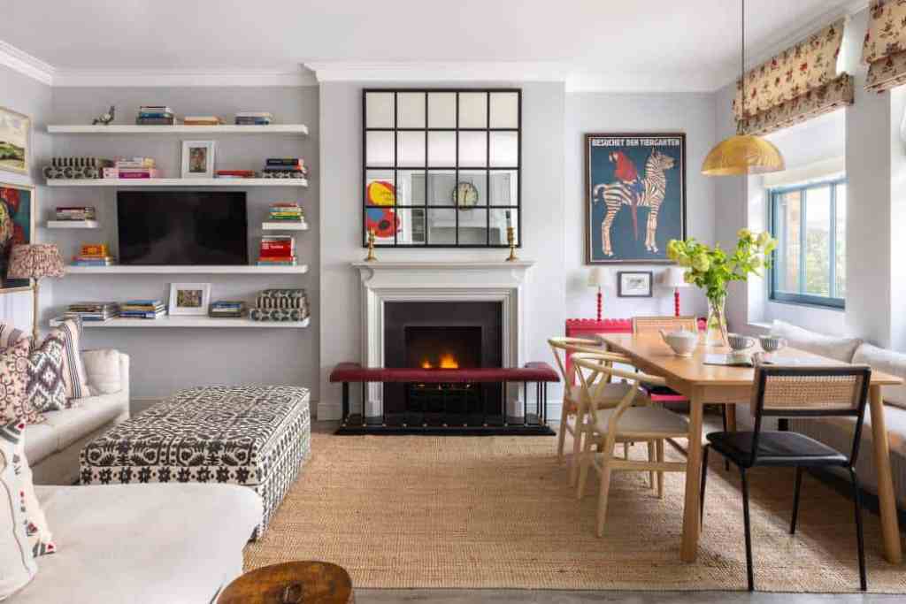 Modern living room with fireplace, bookshelves, and dining area in Knightsbridge Mews House.