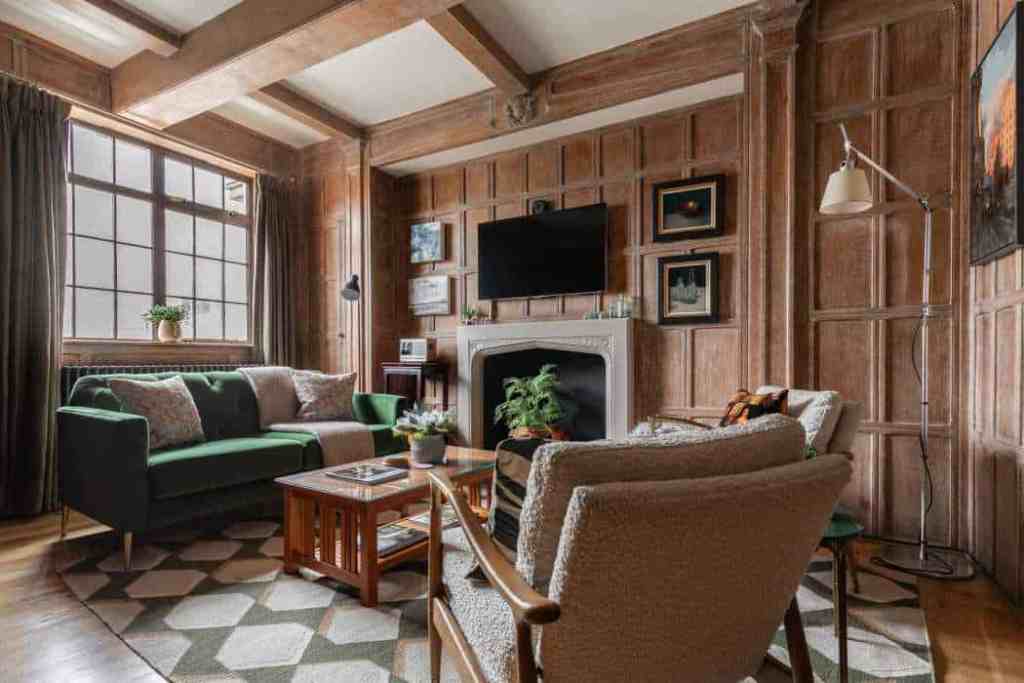 Cozy living room with wooden walls, large window, and modern decor.