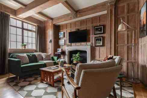 Cozy living room with wooden walls, large window, and modern decor.