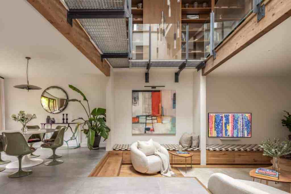 Spacious modern living room with loft, artwork, and cozy seating area.
