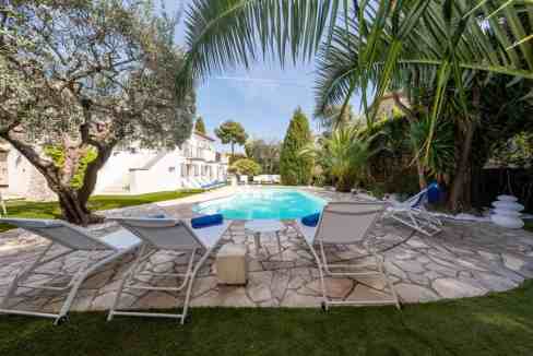 Beautiful private pool with lounge chairs and lush greenery.