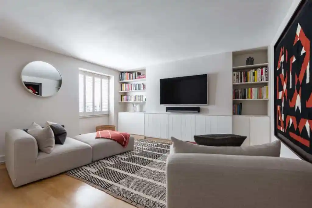 Contemporary living room with TV, bookshelves, and stylish decor.