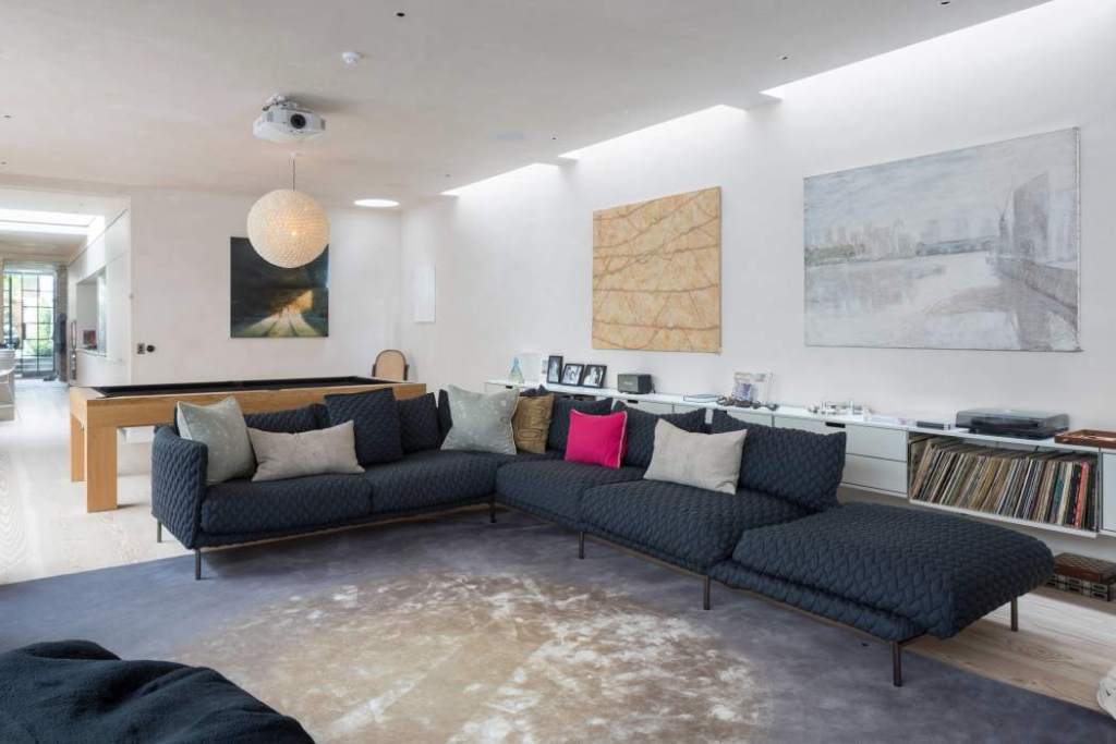 Stylish living room with navy sofa, artwork, and modern decor in Kensington Urban Manor.