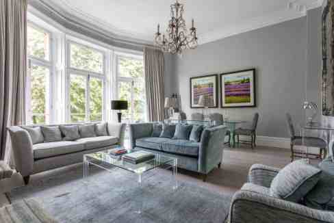 Spacious living room with large bay windows and stylish furniture in South Kensington.