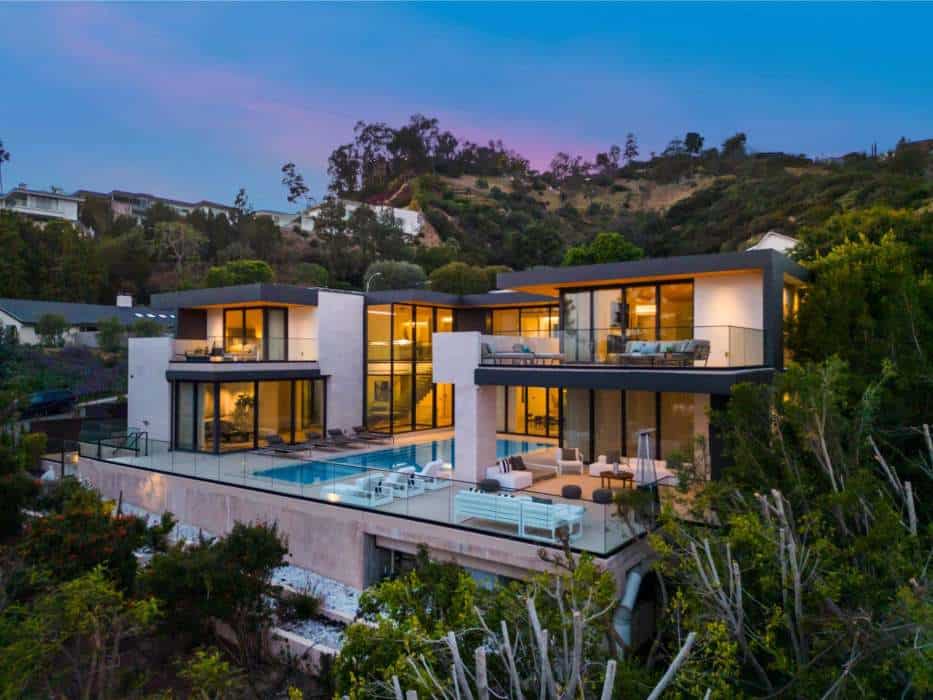 Contemporary villa with infinity pool and hillside views at sunset.