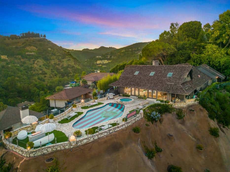 Luxury hillside villa with pool and scenic mountain views at sunset.