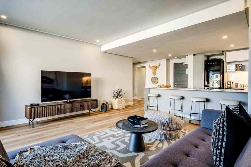 Spacious living room with modern furniture and open-plan kitchen.