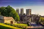York cityscape with historic cathedral and lush park in the foreground.
