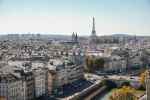Panoramic view of Paris with Eiffel Tower and Seine River on a clear day.