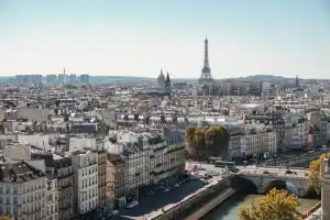 Panoramic view of Paris with Eiffel Tower and Seine River on a clear day.