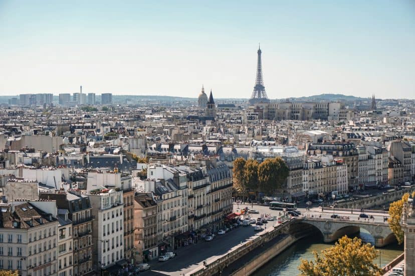 Panoramic view of Paris with Eiffel Tower and Seine River on a clear day.
