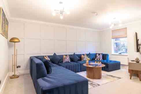Stylish living room with blue sofa and wooden coffee table in Cheltenham.