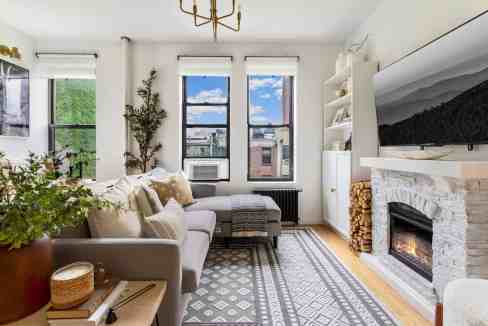 Bright living room with fireplace, large windows, and cozy decor.