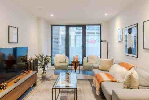 Contemporary living room with large windows, cozy sofas, and modern decor.