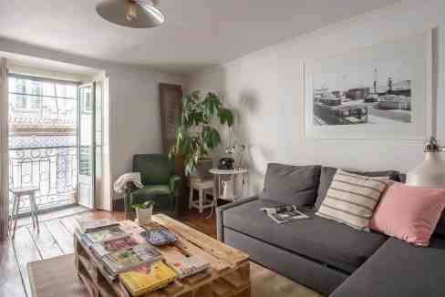 Bright living room with balcony view in Lisbon serviced apartment.