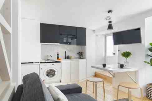 Bright, modern Lisbon apartment with kitchen, seating area, and TV.