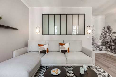 Contemporary living room with white sofa, decorative pillows, and wall art.
