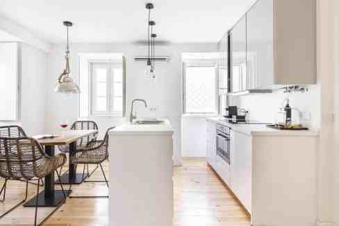 Bright, modern kitchen with white cabinets and wooden flooring in Lisbon.