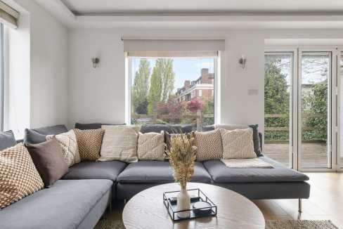 Bright living room with large windows and comfortable sofa seating.