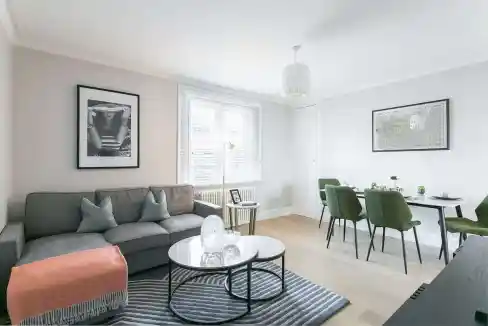 Contemporary living room with sofa, dining area, and natural light in Marylebone Village.