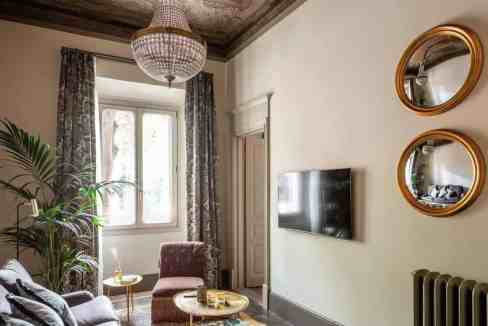 Luxurious living room with ornate ceiling, chandelier, and vintage furniture.