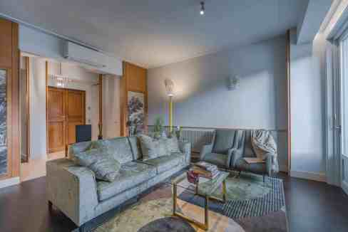 Modern living room with sofas, large window, and stylish decor.