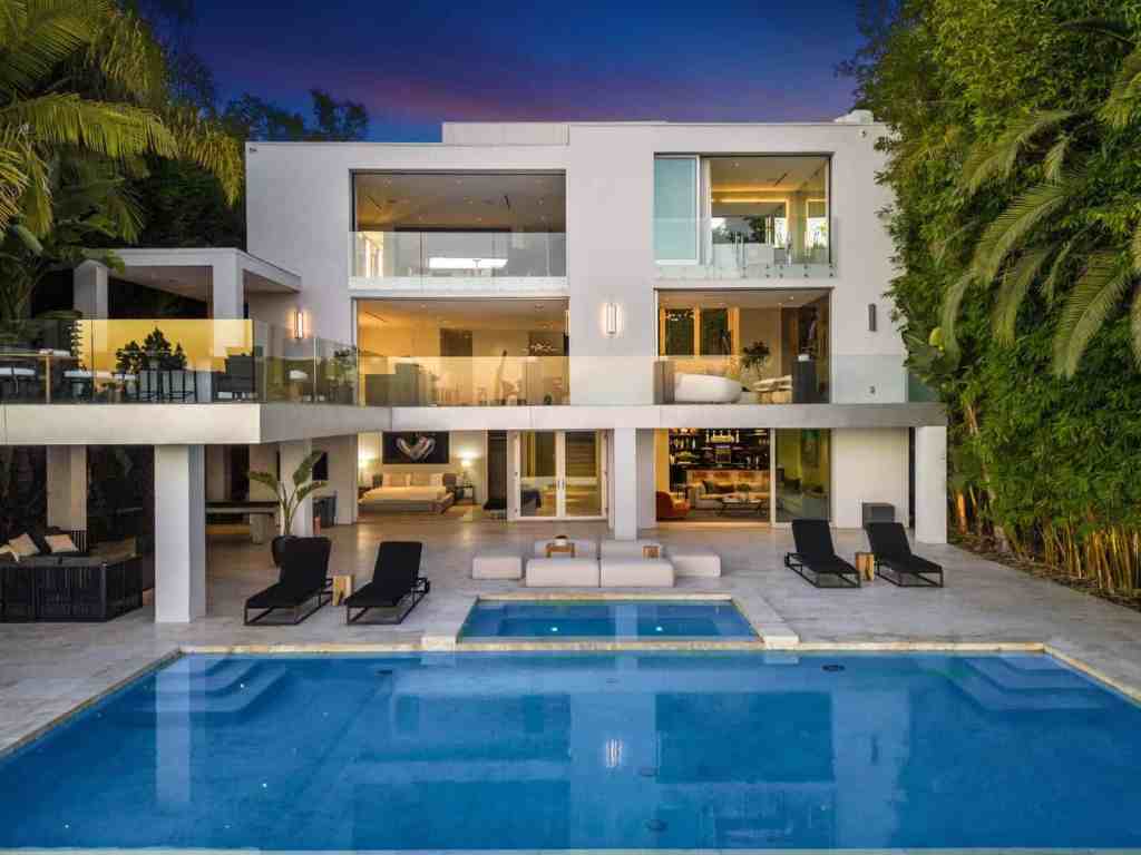 Contemporary villa with pool and outdoor lounging area at sunset.
