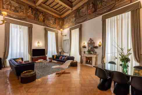 Luxurious living room with high ceilings, frescoed walls, and classic decor.