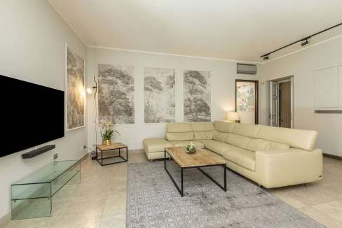 Spacious living room with cream sofa, abstract wall art, and minimalist design.