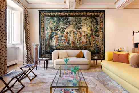 Stylish living room with a large tapestry, sofas, and decorative elements.