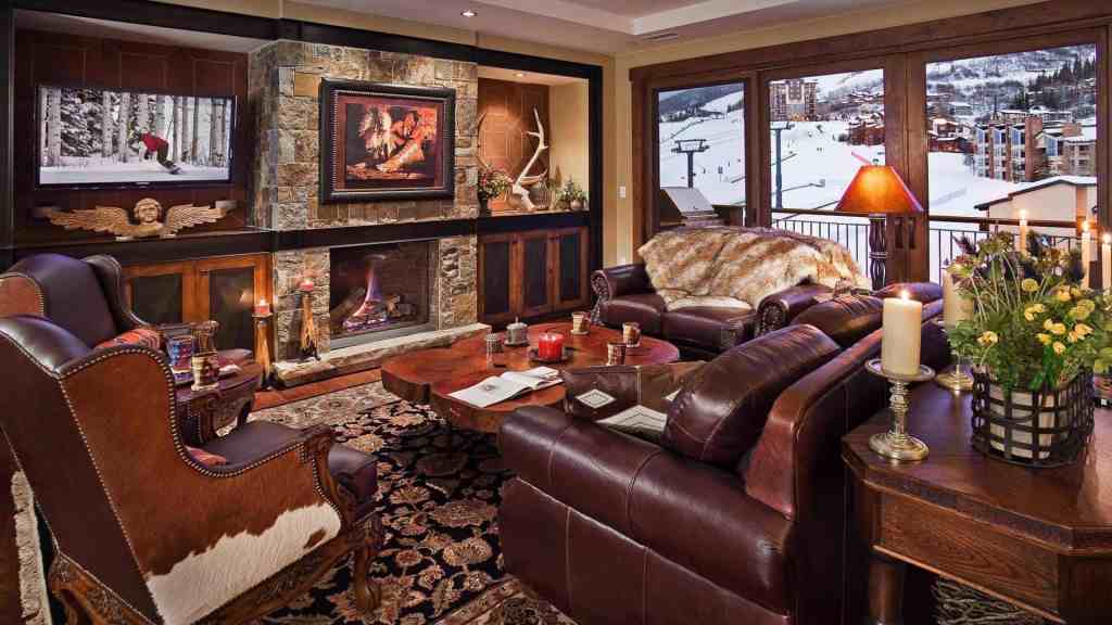 Cozy mountain lodge living room with fireplace and large windows.
